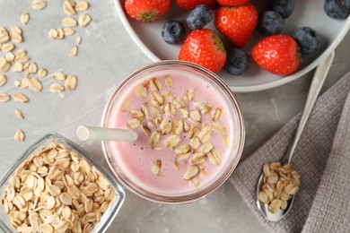 Photo of Jar of tasty berry oatmeal smoothie on grey table, flat lay