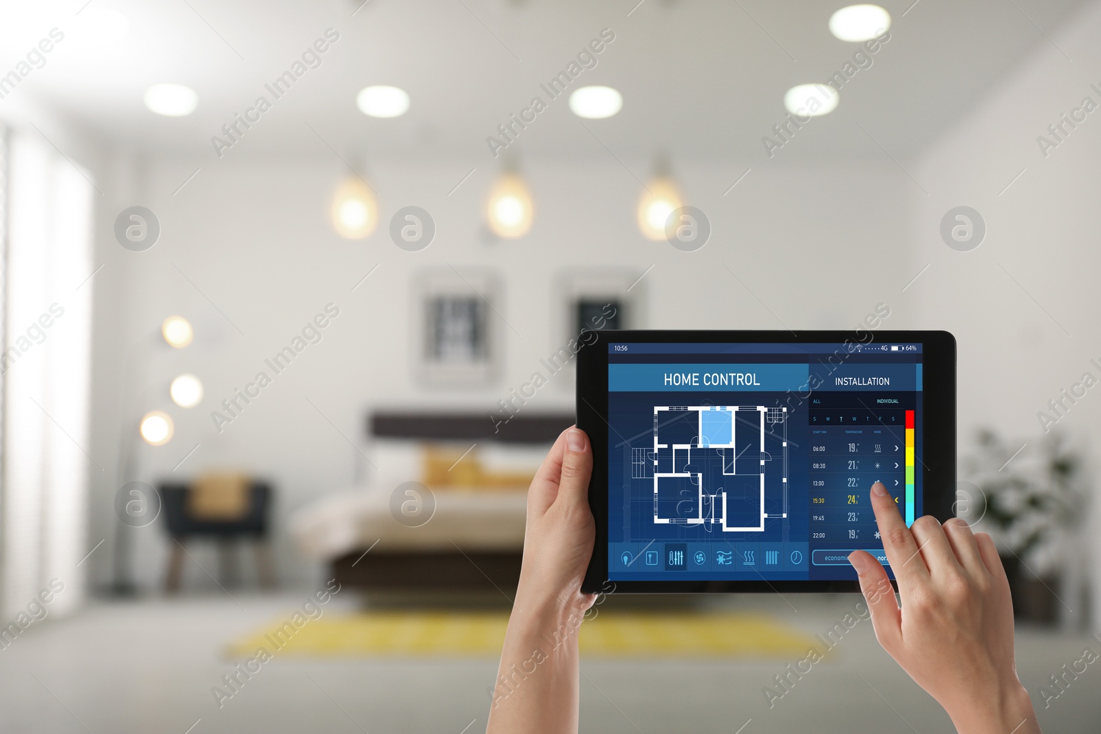 Image of Woman using tablet to set indoor temperature, closeup. Smart home automation system