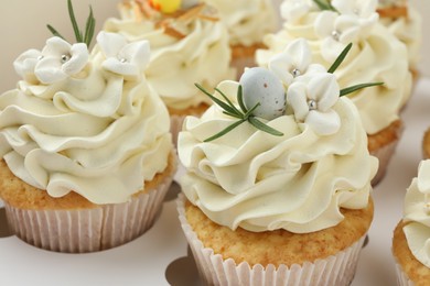 Tasty Easter cupcakes with vanilla cream in box, closeup