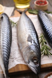 Raw organic mackerel fish on wooden board, closeup