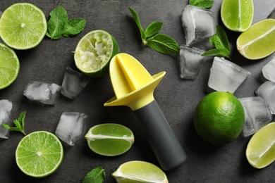 Photo of Flat lay composition with lime, mint and juicer on grey background. Refreshing beverage ingredients