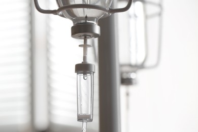 Photo of IV drip against blurred light background, space for text