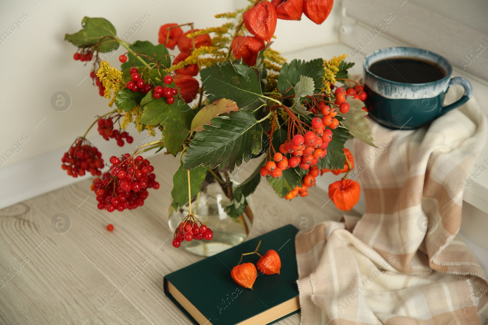Photo of Beautiful autumn composition with cup of drink and book indoors