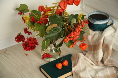 Photo of Beautiful autumn composition with cup of drink and book indoors