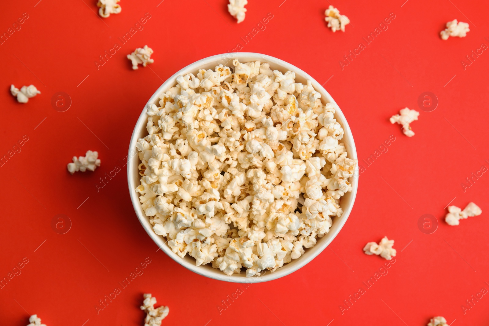 Photo of Tasty pop corn on red background, flat lay