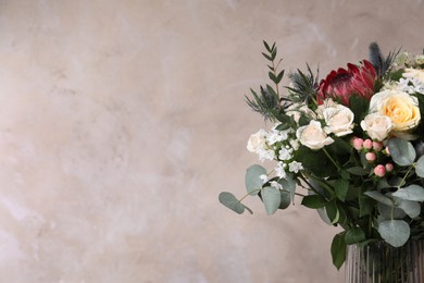 Photo of Beautiful bouquet with roses on beige background, closeup. Space for text