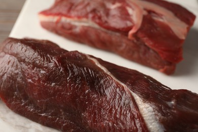 Pieces of raw beef meat on marble board, closeup