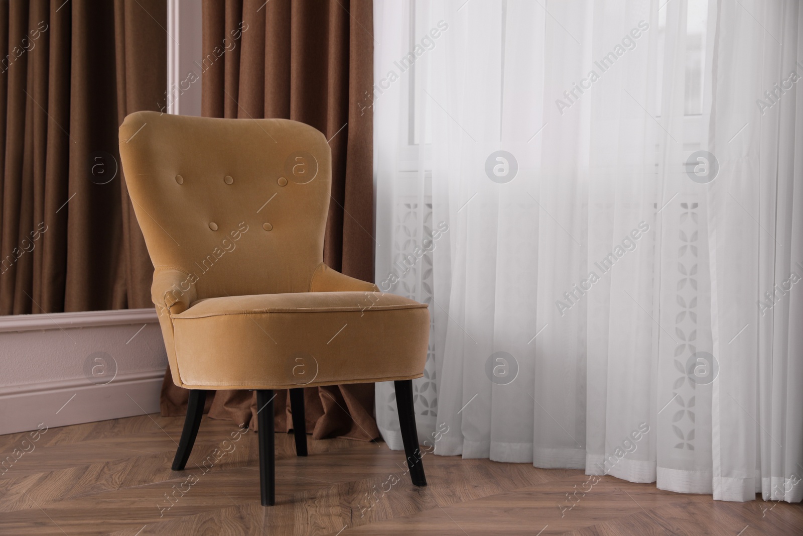 Photo of Comfortable armchair near window indoors, space for text. Interior design