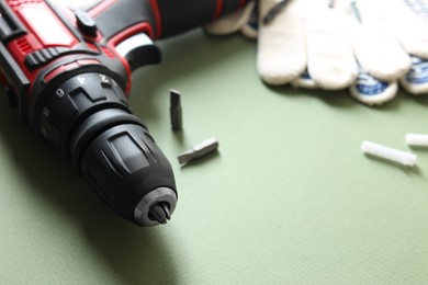 Electric screwdriver on pale green background, closeup. Space for text