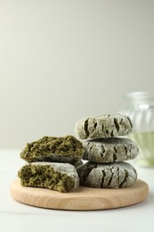 Board with stacked tasty matcha cookies on white table. Space for text
