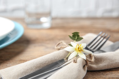 Cutlery set and dishware on wooden table, closeup