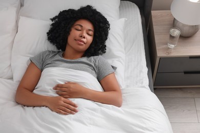 Beautiful young woman sleeping in soft bed at home