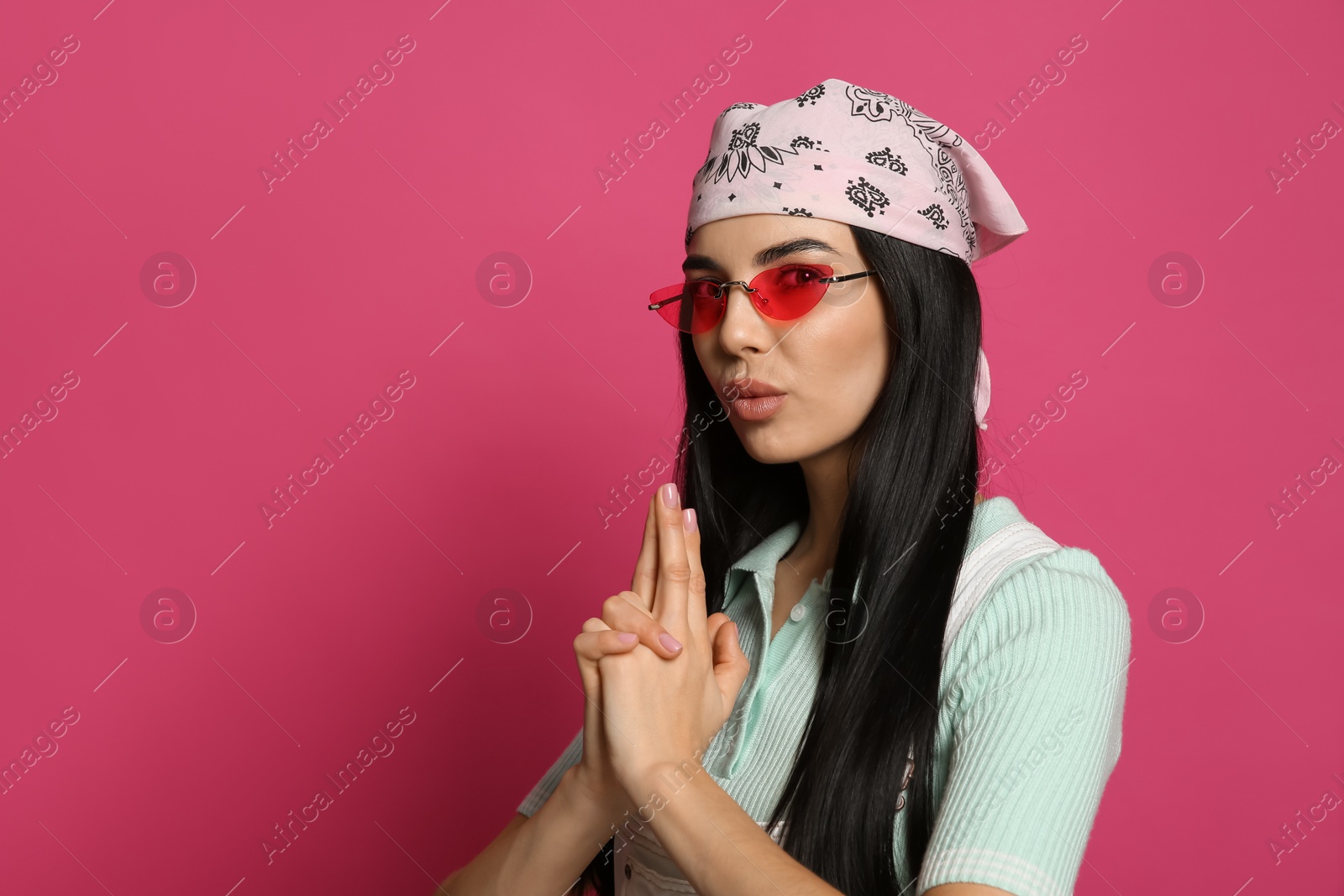 Photo of Young woman wearing stylish bandana and sunglasses on pink background, space for text