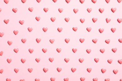 Photo of Tasty bright heart shaped sprinkles on pink background, flat lay