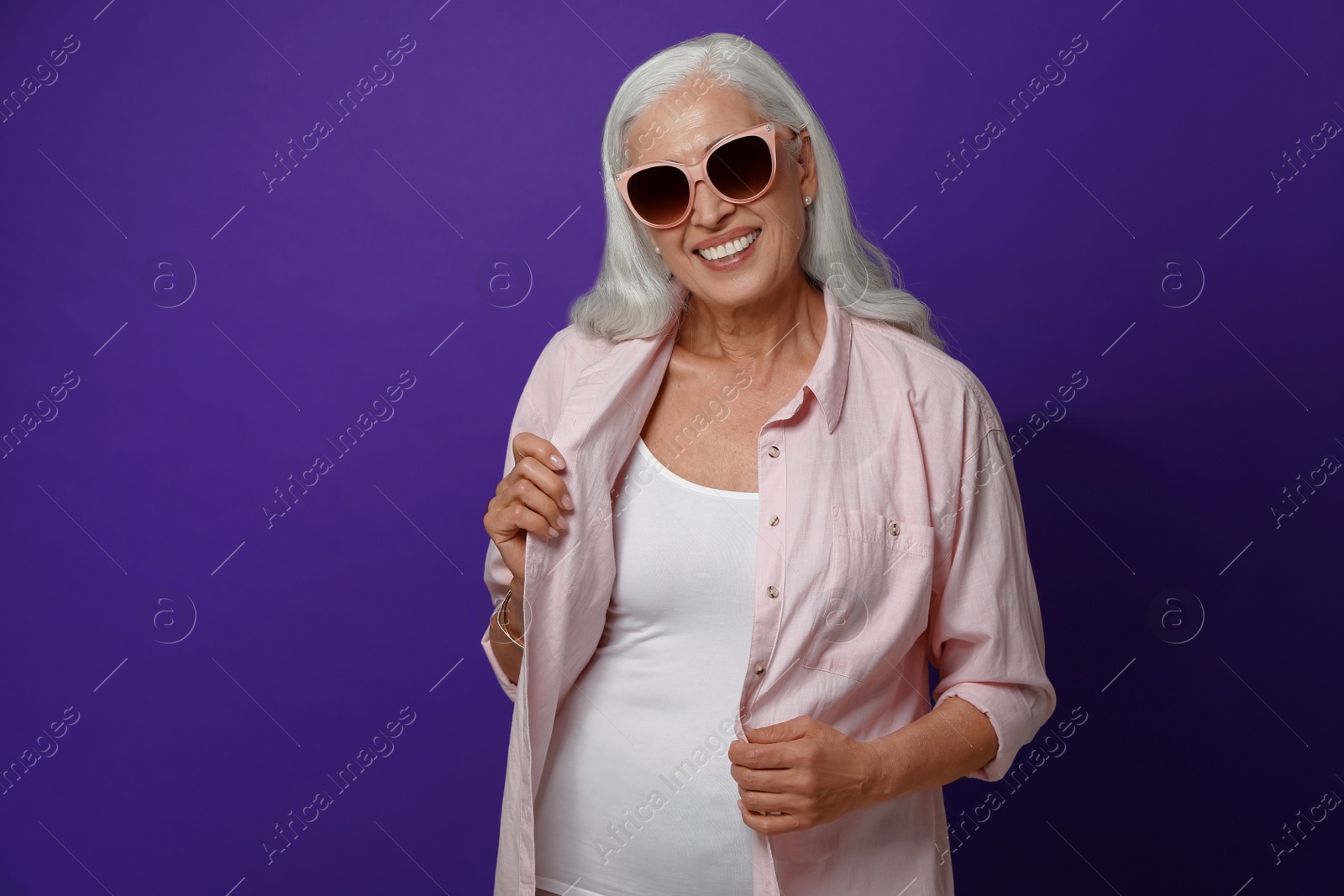 Photo of Portrait of beautiful mature woman on violet background