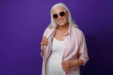Portrait of beautiful mature woman on violet background