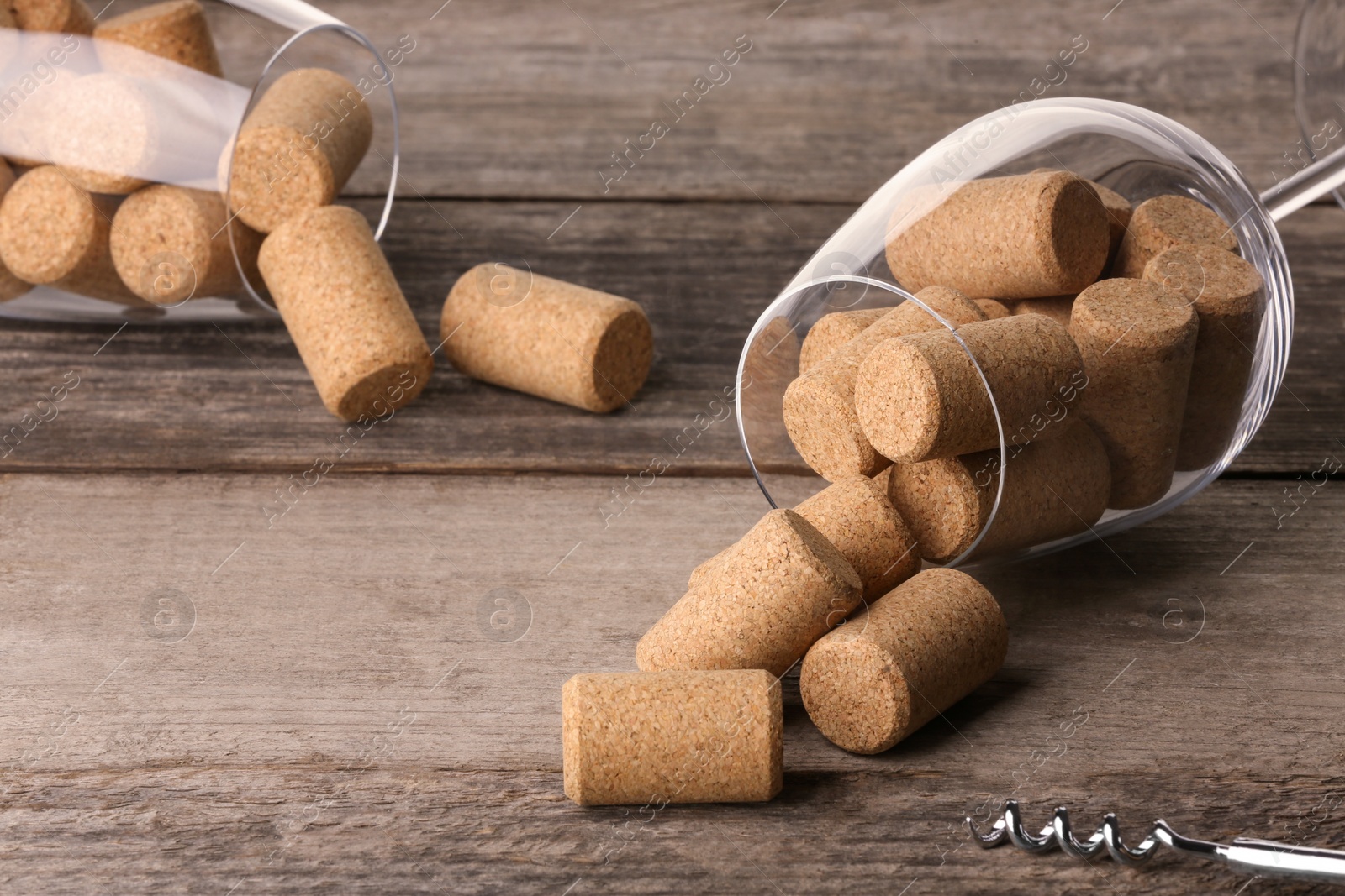 Photo of Glasses with wine corks and corkscrew on wooden table