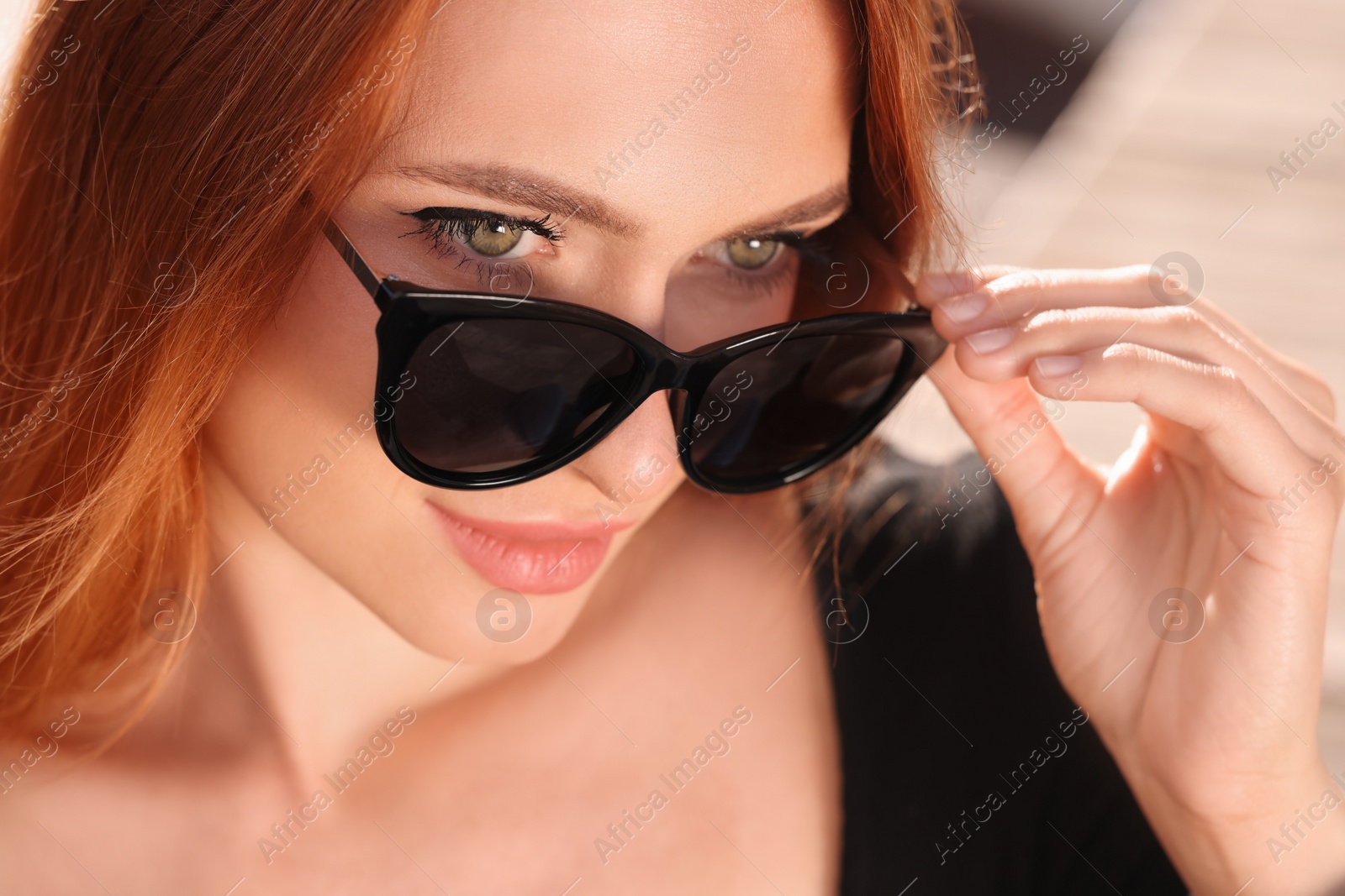 Photo of Beautiful woman in sunglasses outdoors on sunny day, closeup