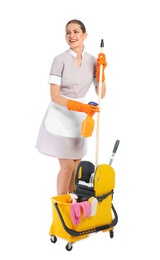 Young chambermaid with cleaning supplies on white background