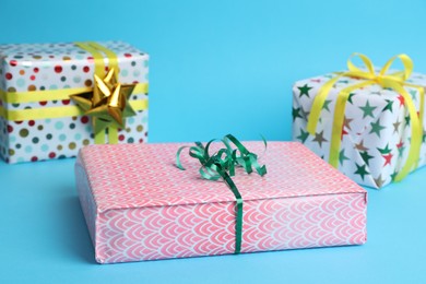 Photo of Beautifully wrapped gift boxes on light blue background