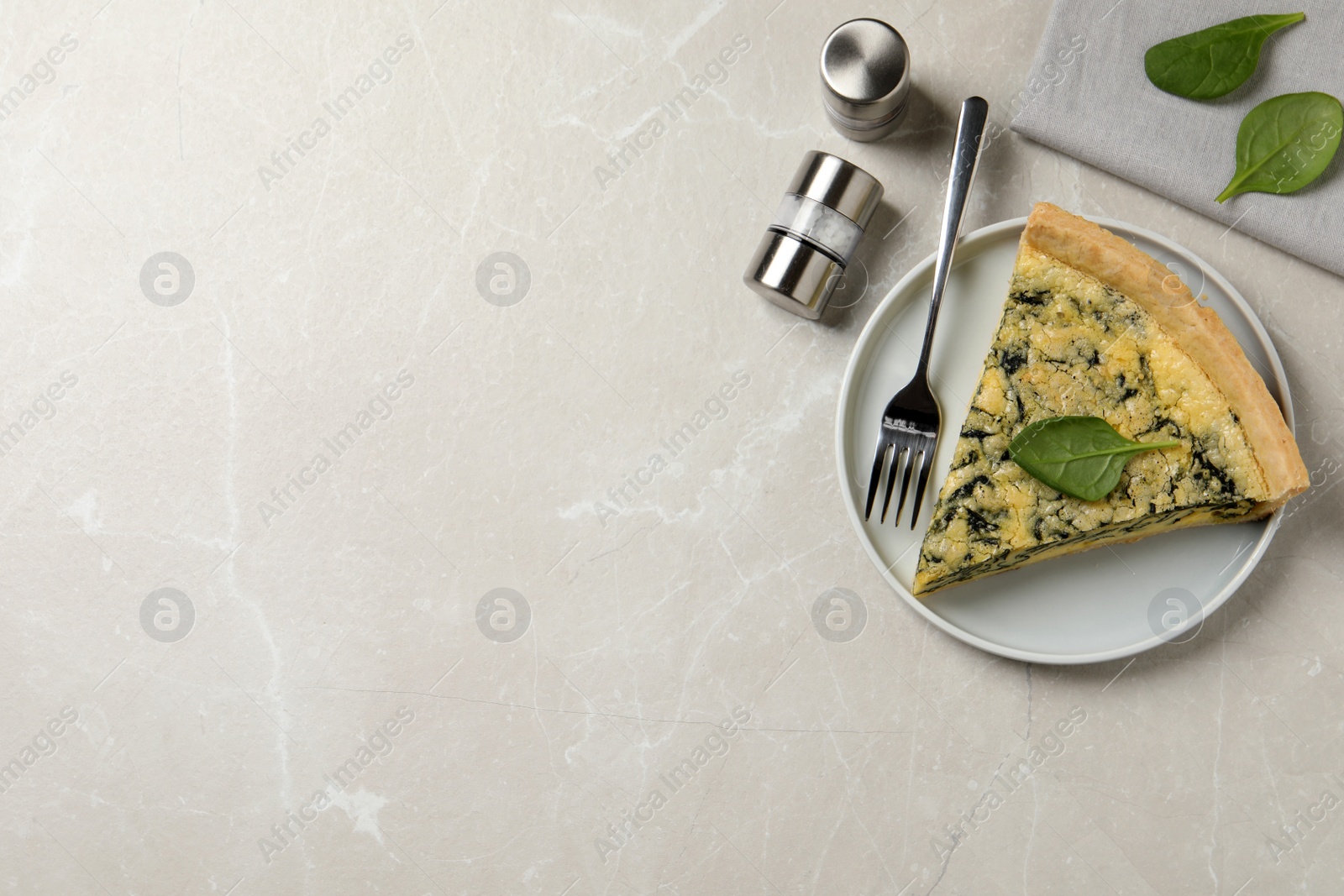Photo of Piece of delicious spinach pie served on light marble table, flat lay. Space for text