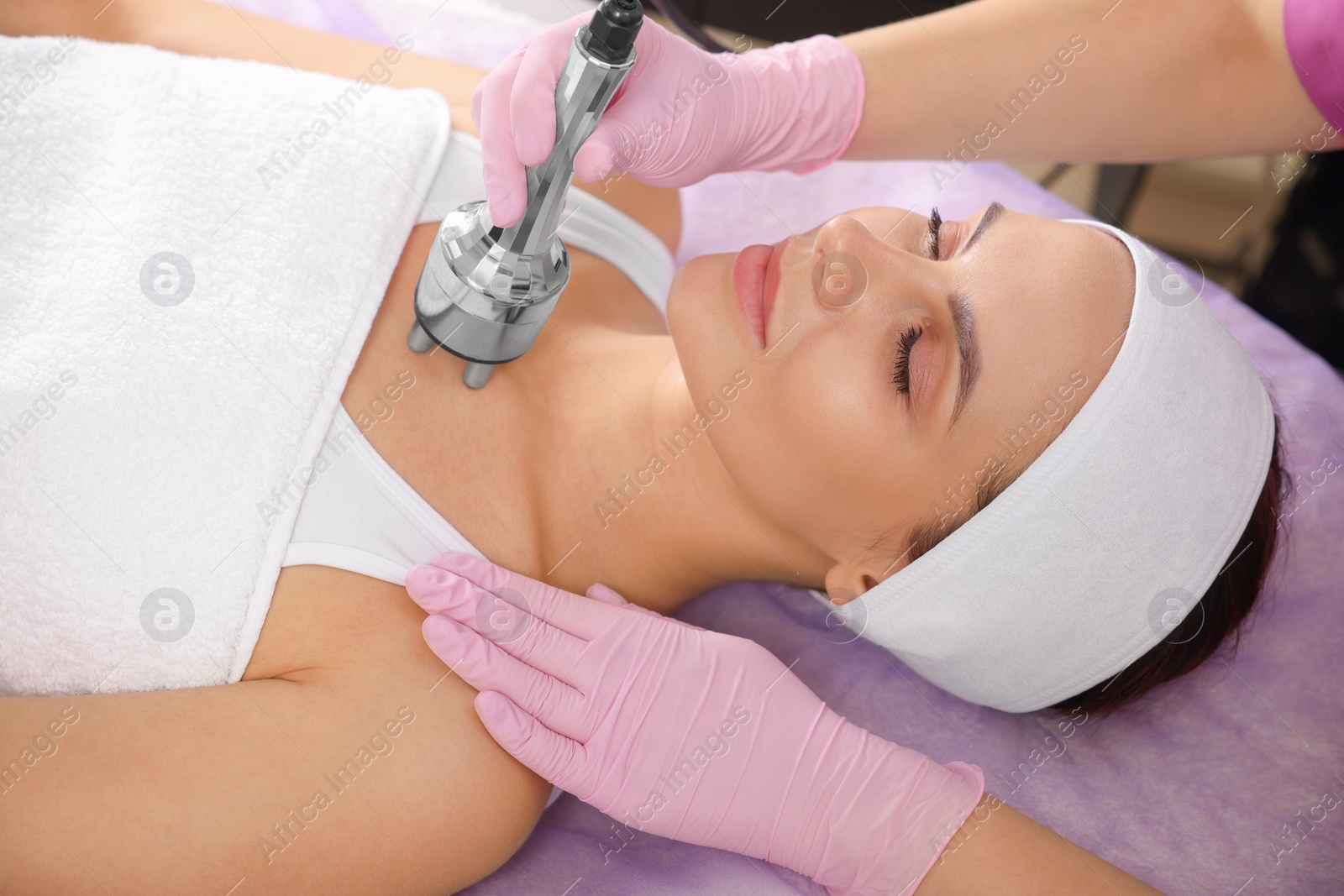 Photo of Young woman undergoing cosmetic procedure in beauty salon. Microcurrent therapy