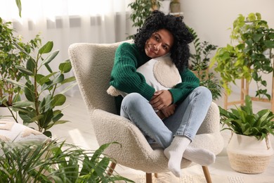 Woman relaxing surrounded by beautiful houseplants at home