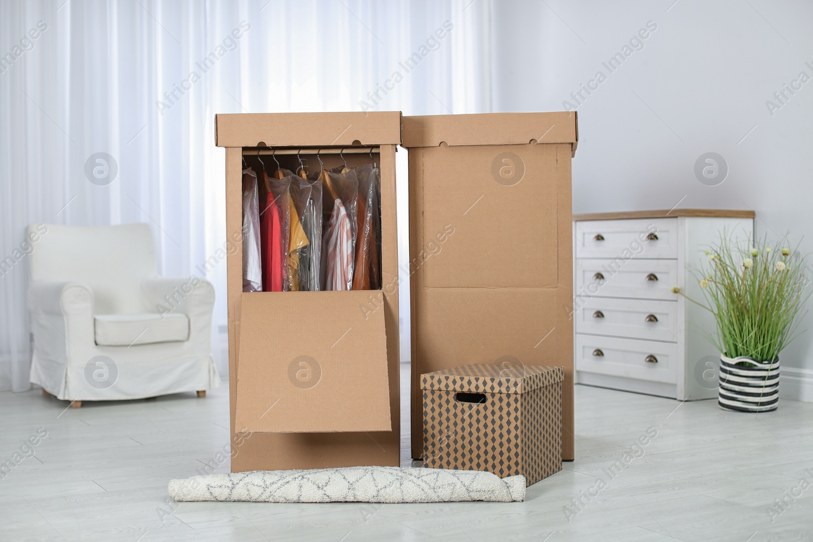 Photo of Wardrobe boxes with clothes in living room