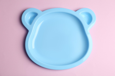 Cute animal shaped plate on light pink background, top view. Serving baby food