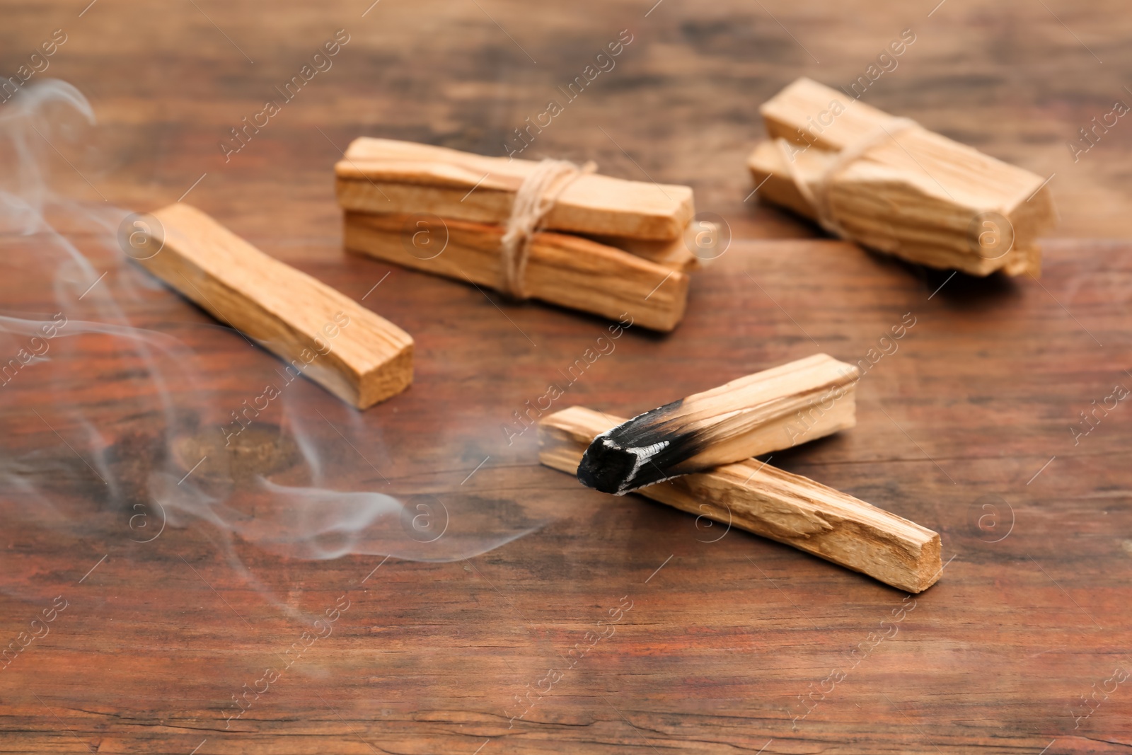 Photo of Palo Santo stick smoldering on wooden table