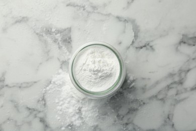 Baking powder in jar on white marble table, top view