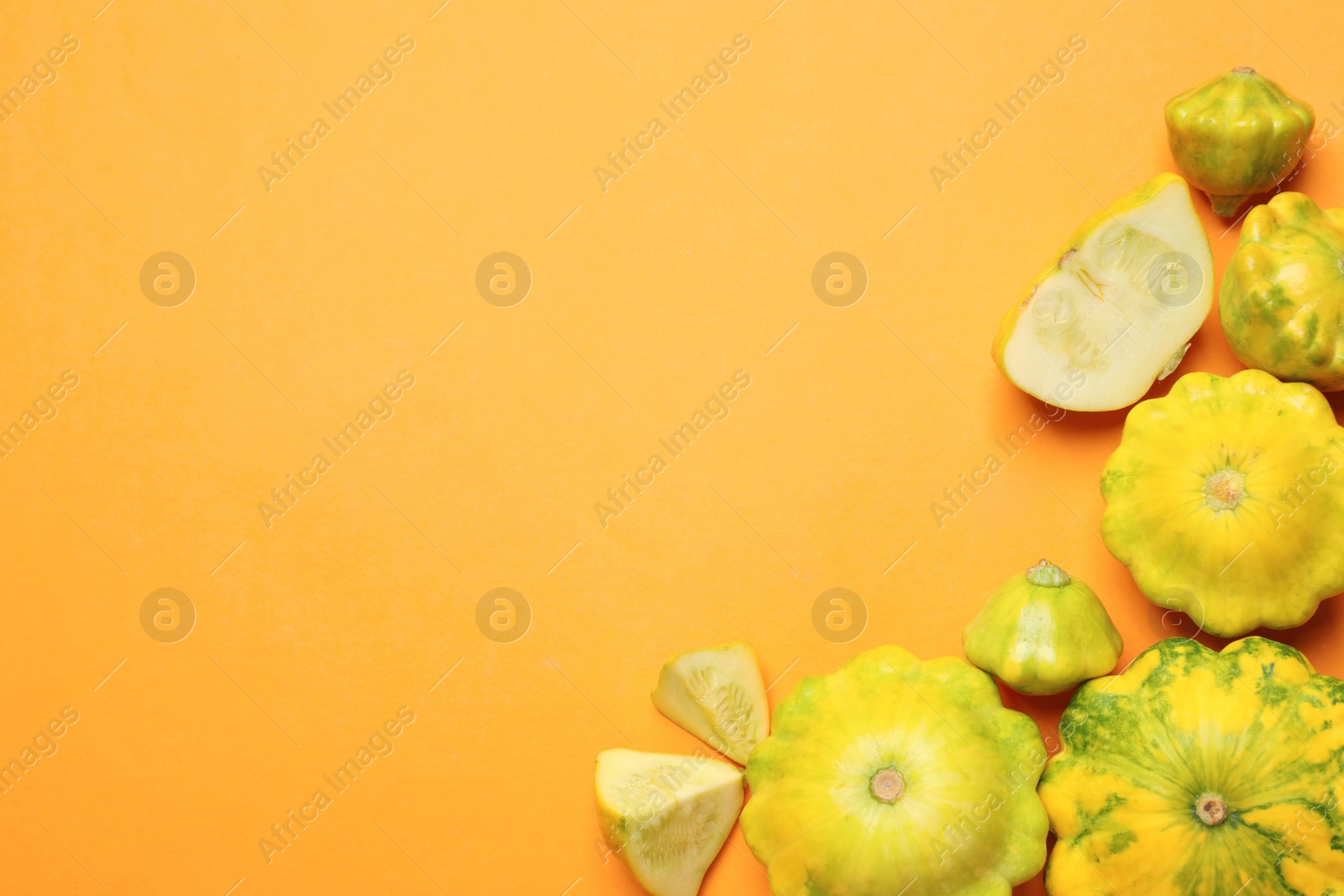 Photo of Fresh ripe pattypan squashes on orange background, flat lay. Space for text