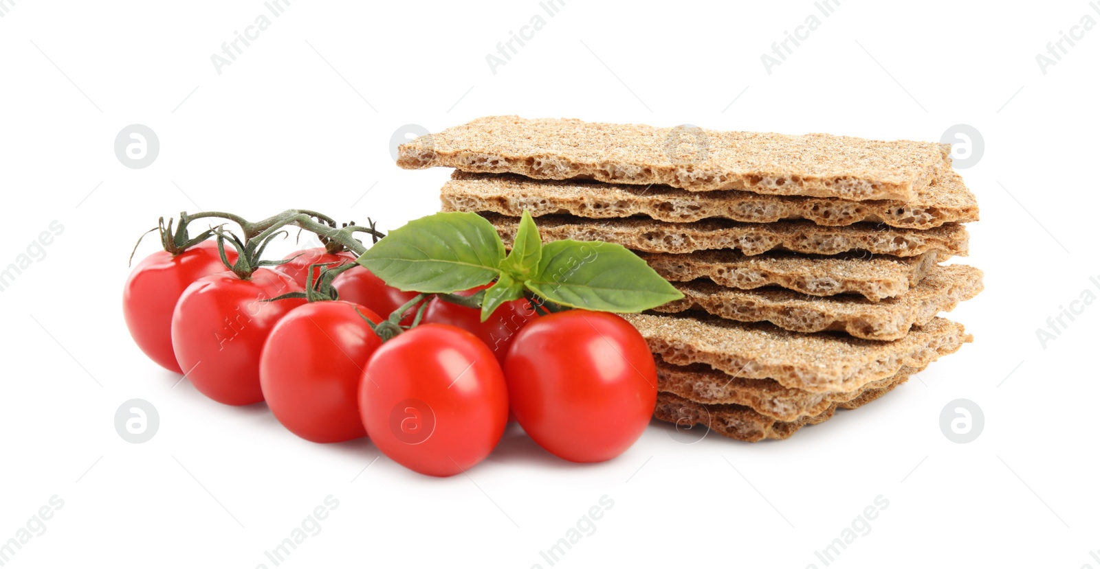 Photo of Crunchy rye crispbreads, fresh cherry tomatoes and basil on white background