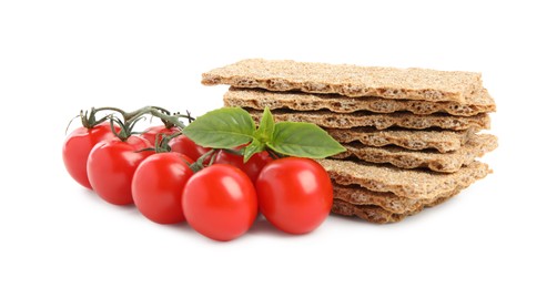 Photo of Crunchy rye crispbreads, fresh cherry tomatoes and basil on white background