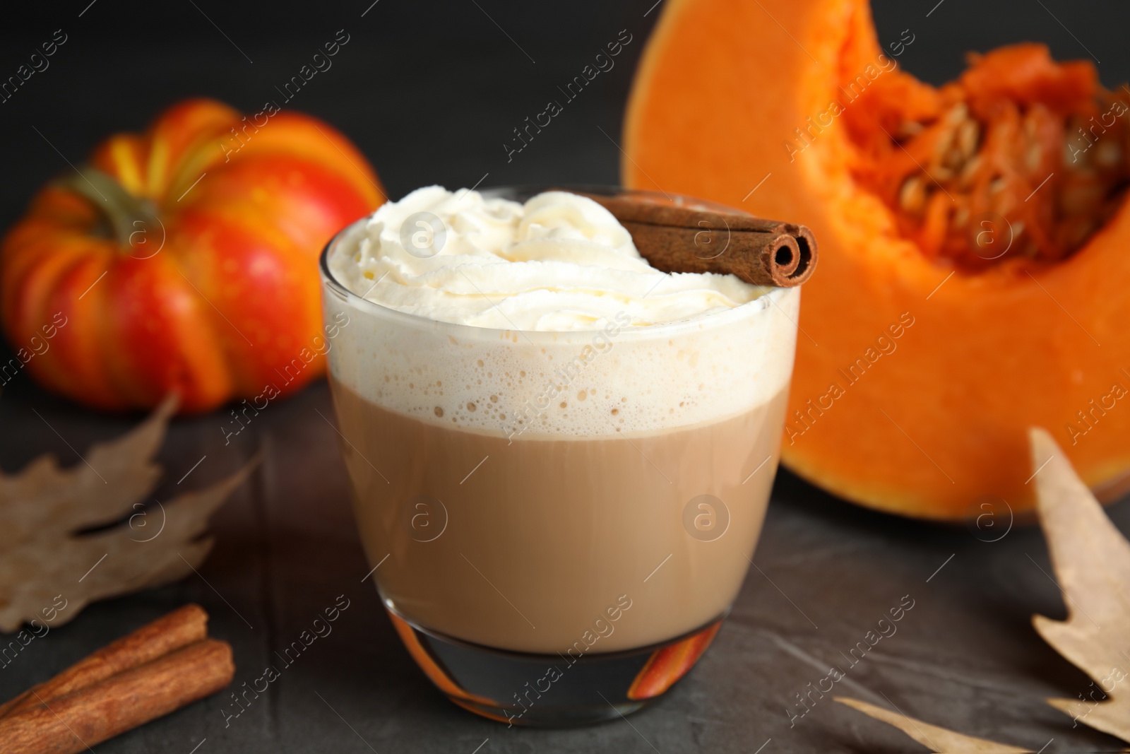 Photo of Composition with pumpkin spice latte in glass on table