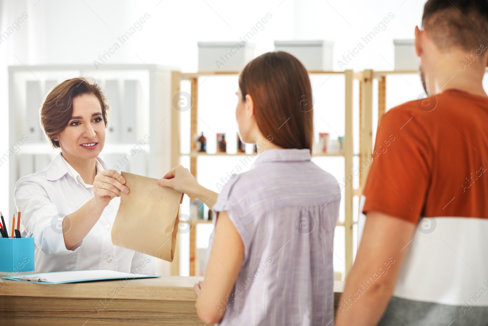 Photo of Pharmacist giving medicine to customer in drugstore