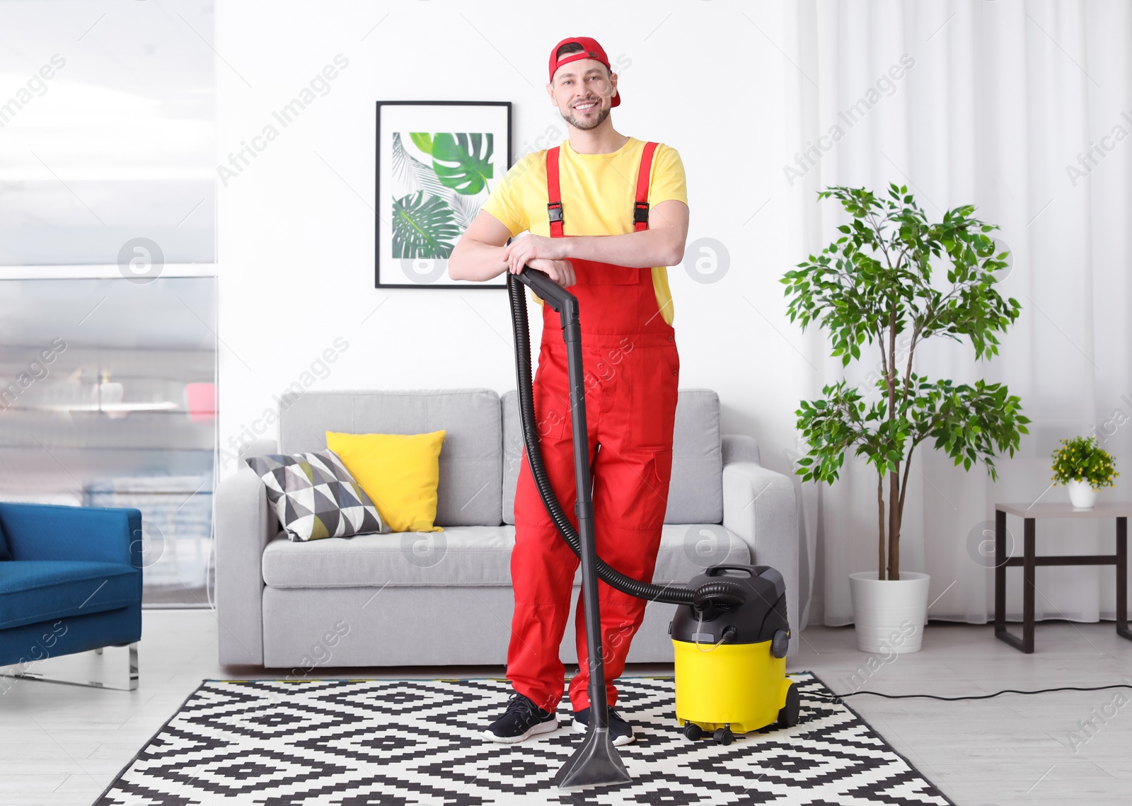 Photo of Mature man hoovering carpet with vacuum cleaner in living room