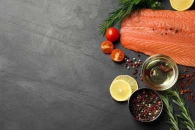 Photo of Fresh raw salmon and ingredients for marinade on black table, flat lay. Space for tex