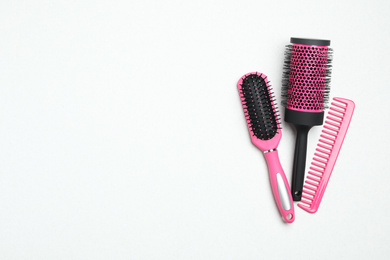 Photo of Modern hair comb and brushes on white background, flat lay. Space for text