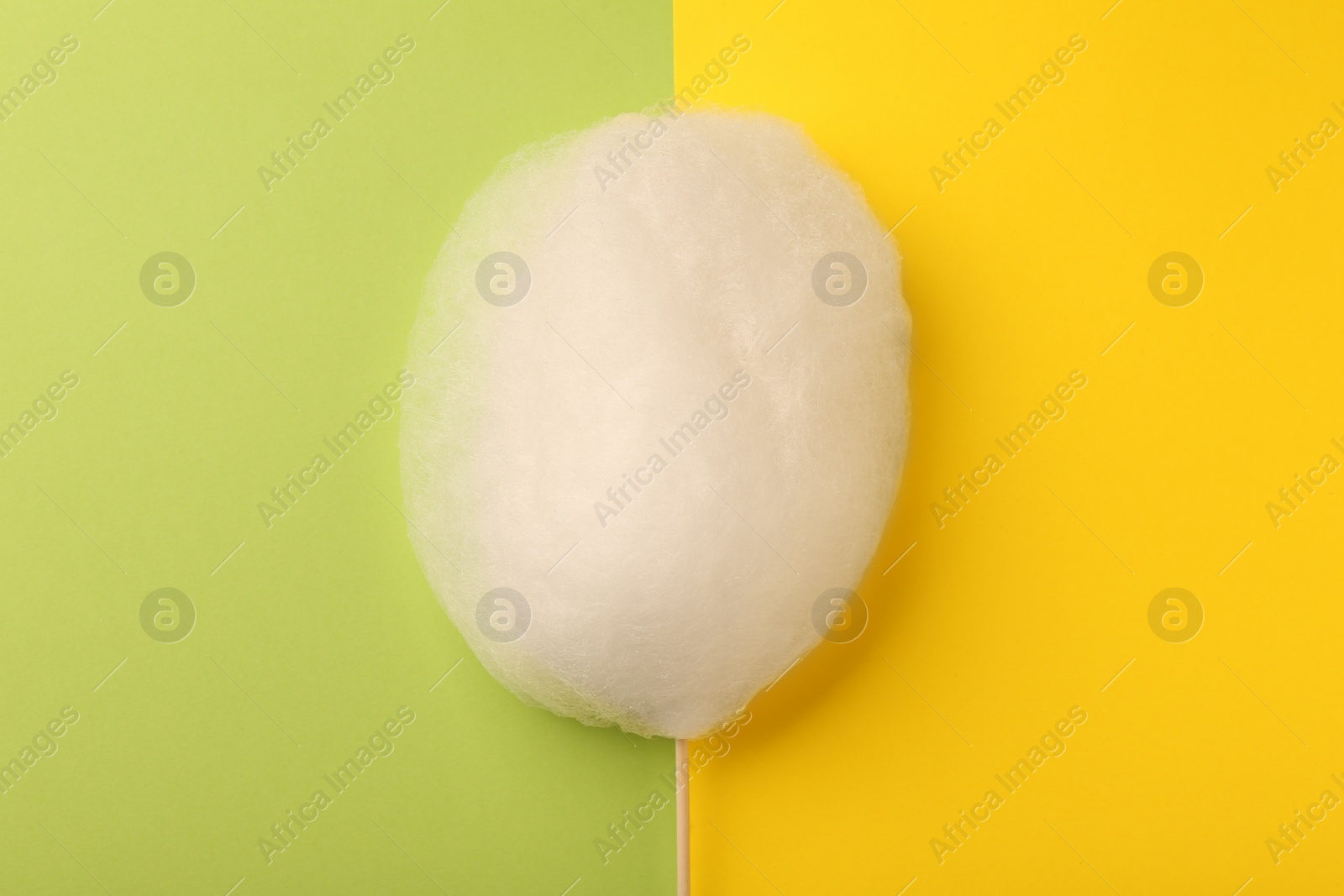 Photo of One sweet cotton candy on color background, top view