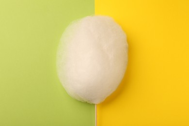 Photo of One sweet cotton candy on color background, top view