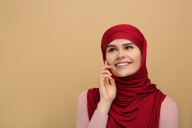 Photo of Portrait of Muslim woman in hijab on beige background, space for text