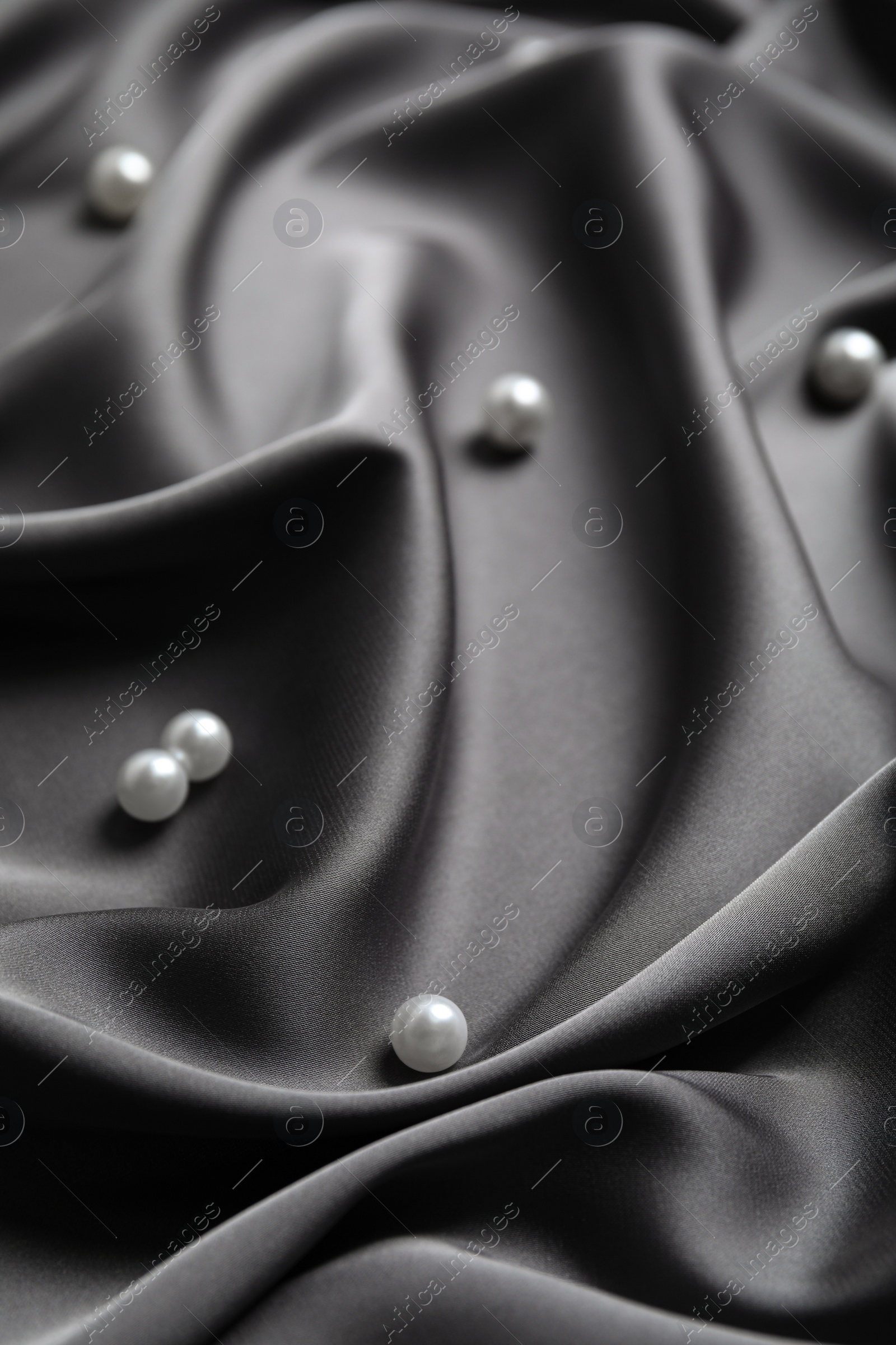 Photo of Many beautiful pearls on delicate black silk, closeup