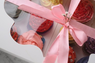 Different colorful cupcakes in box, closeup view