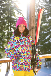 Photo of Young woman with ski wearing winter sport clothes in forest