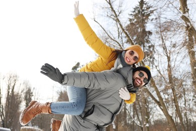 Photo of Happy young couple having fun outdoors on winter day, low angle view