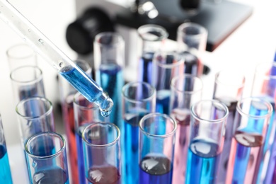 Photo of Dripping reagent into test tube with sample in chemistry laboratory, closeup