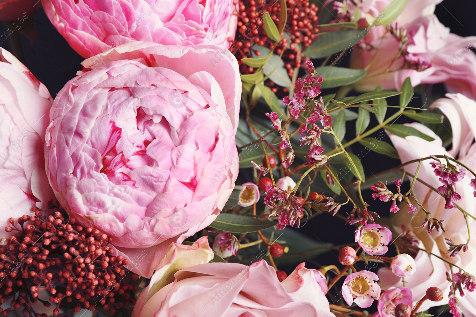 Photo of Beautiful fresh bouquet on dark background, closeup. Floral decor