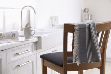 Photo of Dry towel on wooden chair in kitchen