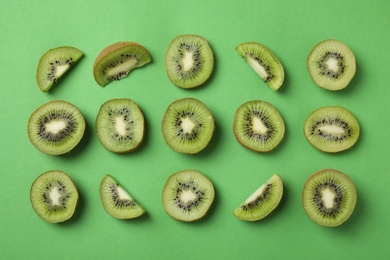 Photo of Top view of sliced fresh kiwis on green background